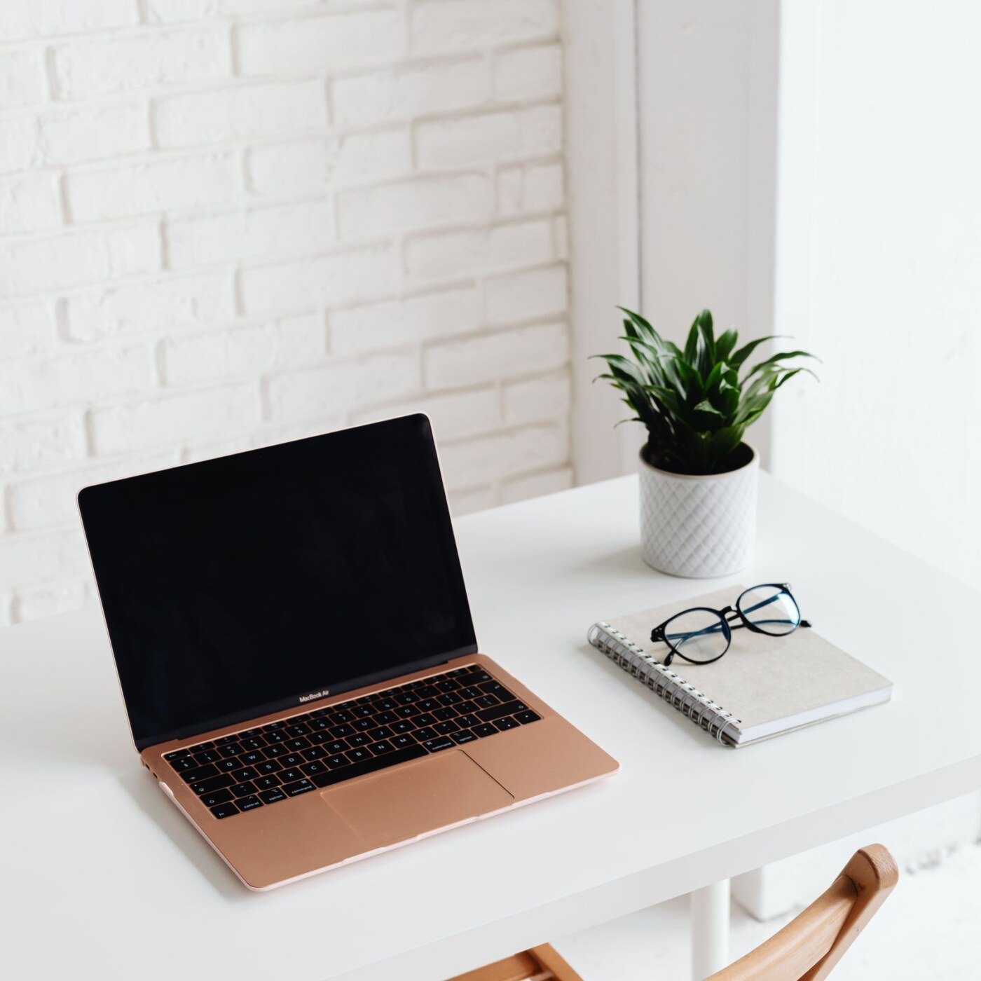 MacBook con libreta y bolígrafo